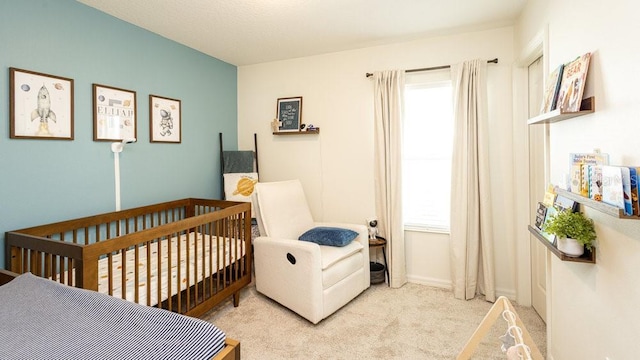 bedroom featuring light colored carpet and a crib