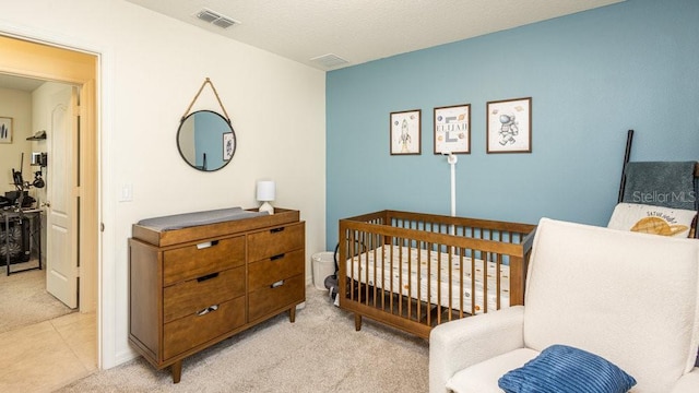 bedroom with light carpet, light tile patterned floors, and visible vents