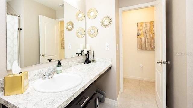 bathroom with tile patterned flooring, vanity, and baseboards