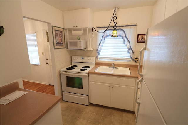 kitchen with decorative light fixtures, white cabinetry, sink, a healthy amount of sunlight, and white appliances