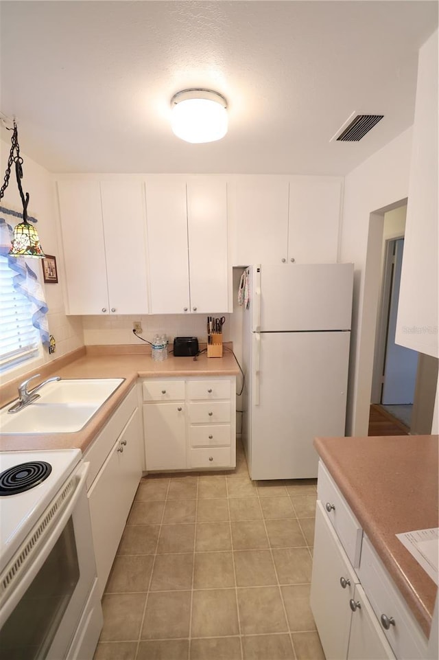 kitchen with white cabinetry, hanging light fixtures, white appliances, and sink