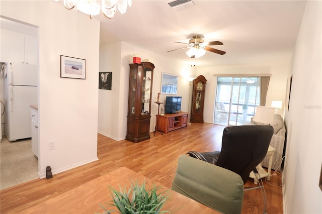 living room with ceiling fan and light wood-type flooring