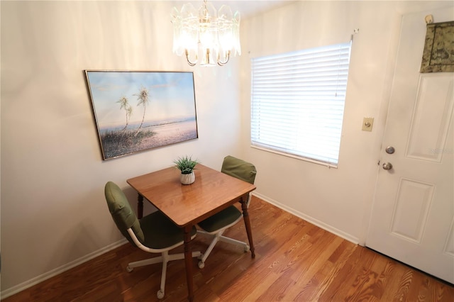 dining room with hardwood / wood-style flooring and a notable chandelier