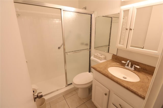 bathroom featuring vanity, toilet, tile patterned flooring, and a shower with door