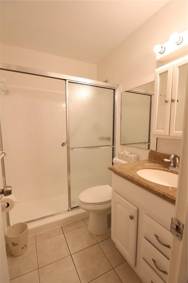 bathroom with vanity, toilet, an enclosed shower, and tile patterned flooring