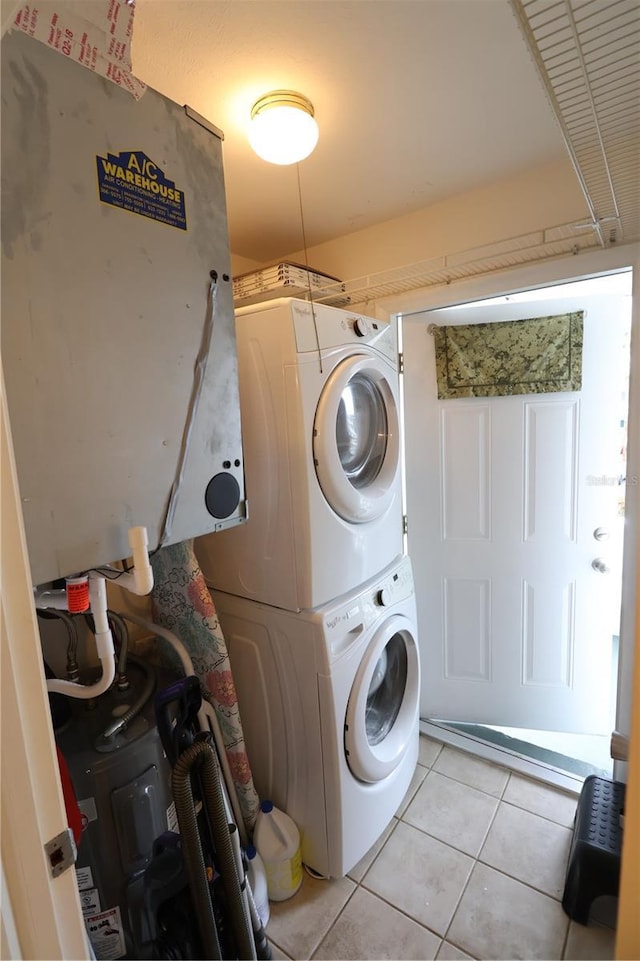 clothes washing area with stacked washer and clothes dryer and light tile patterned floors