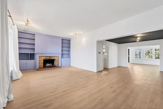 unfurnished living room with a fireplace and light wood-type flooring