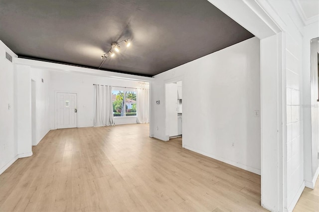 unfurnished room featuring track lighting and light wood-type flooring