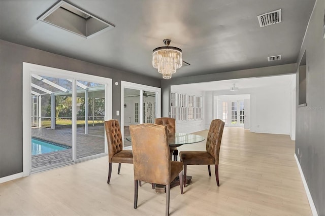 dining room featuring light hardwood / wood-style flooring, a notable chandelier, and a wealth of natural light