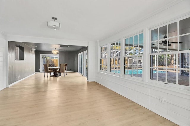 unfurnished sunroom featuring ceiling fan