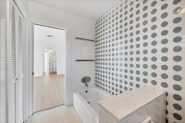 bathroom with tile patterned floors and a bathtub