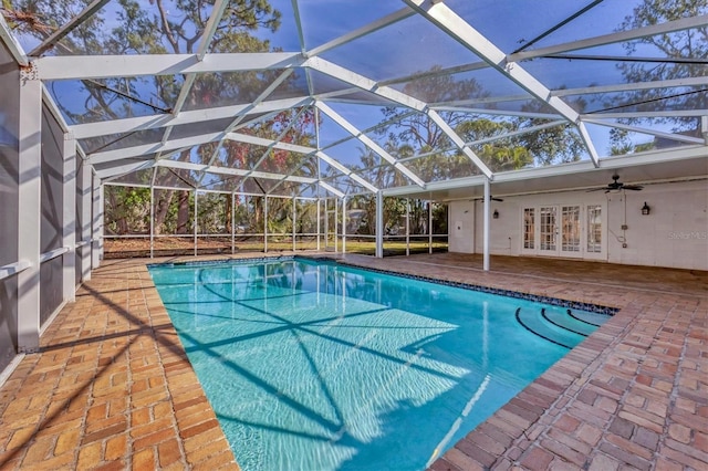 view of pool with french doors, ceiling fan, a lanai, and a patio