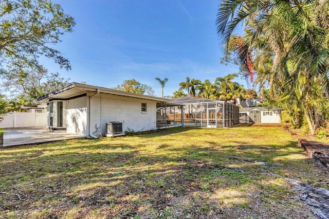 rear view of property with a patio, a lanai, a yard, and cooling unit