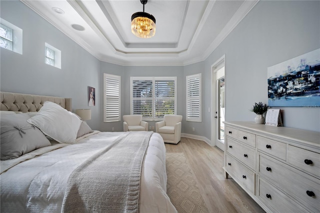 bedroom with baseboards, ornamental molding, a tray ceiling, light wood-style floors, and a notable chandelier