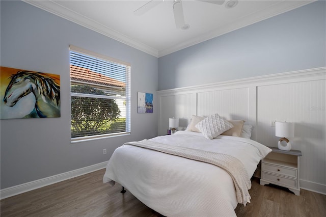 bedroom with baseboards, wainscoting, ceiling fan, ornamental molding, and wood finished floors