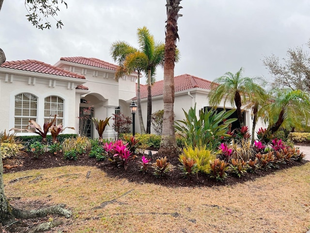 view of front of home featuring a garage, stucco siding, and a tiled roof