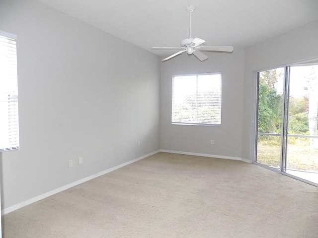 spare room featuring light carpet and ceiling fan