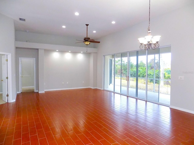 spare room with dark hardwood / wood-style flooring, a towering ceiling, and ceiling fan with notable chandelier