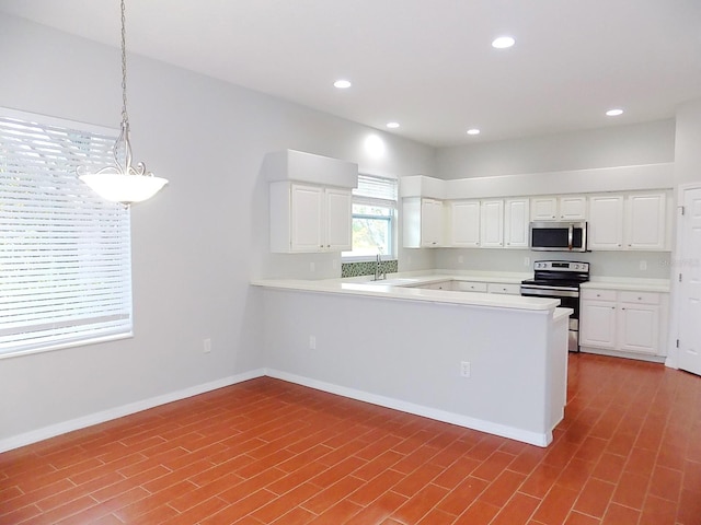 kitchen featuring appliances with stainless steel finishes, pendant lighting, white cabinets, and kitchen peninsula