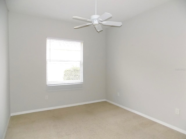 carpeted empty room featuring ceiling fan