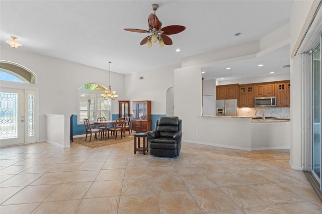 interior space with baseboards, ceiling fan with notable chandelier, arched walkways, and recessed lighting