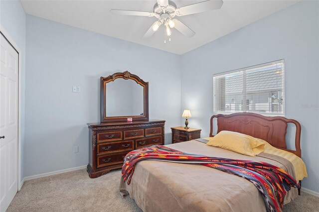 bedroom featuring a closet, light carpet, ceiling fan, and baseboards