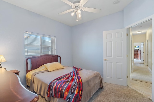 bedroom with light carpet, ceiling fan, and light tile patterned flooring