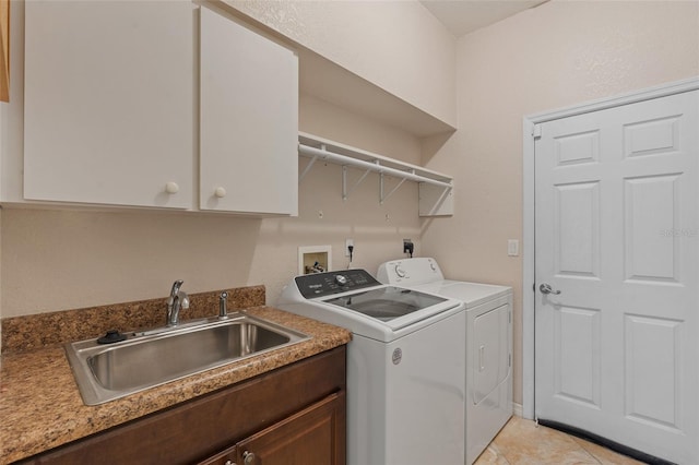 laundry area with cabinet space, washing machine and dryer, and a sink