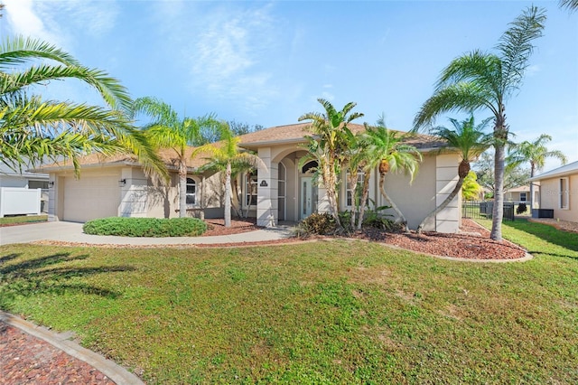 view of front of property with stucco siding, fence, a garage, driveway, and a front lawn