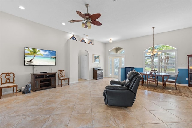 living room with recessed lighting, arched walkways, baseboards, and ceiling fan with notable chandelier