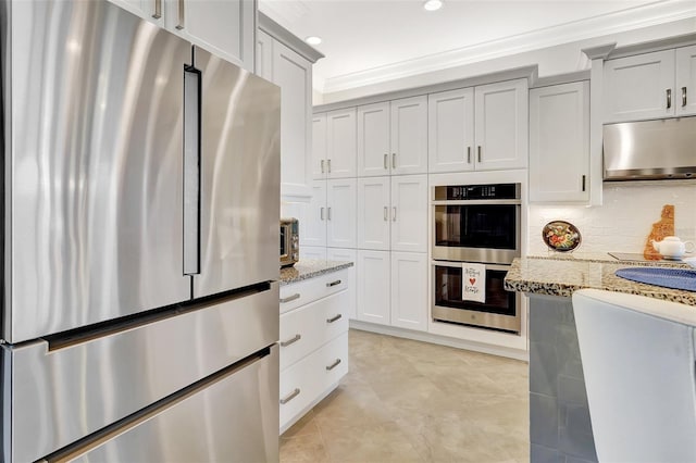 kitchen featuring appliances with stainless steel finishes, tasteful backsplash, gray cabinetry, ornamental molding, and light stone counters