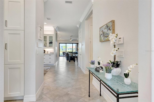 hall featuring ornamental molding and light tile patterned flooring