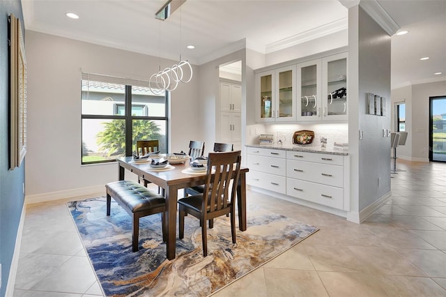 dining room with ornamental molding, light tile patterned floors, and a chandelier