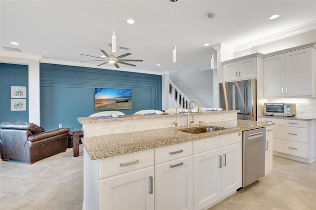 kitchen featuring decorative light fixtures, white cabinetry, sink, a kitchen island with sink, and stainless steel appliances