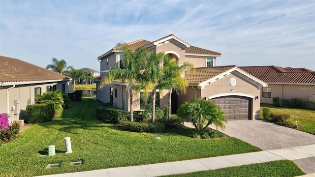 mediterranean / spanish-style house featuring a garage and a front yard