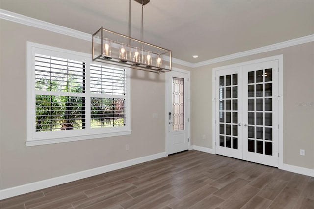 interior space featuring wood finished floors, baseboards, french doors, crown molding, and a notable chandelier