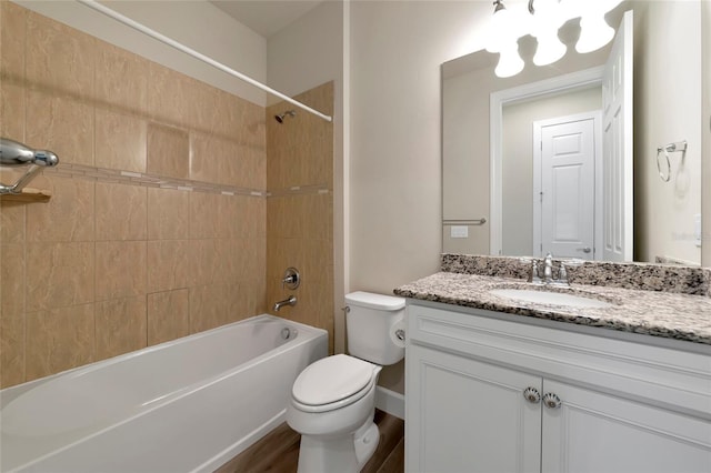 full bathroom featuring tiled shower / bath combo, vanity, wood-type flooring, and toilet