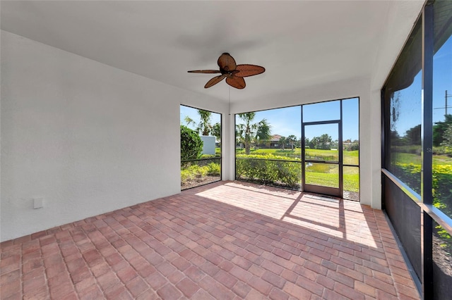 unfurnished sunroom featuring a ceiling fan