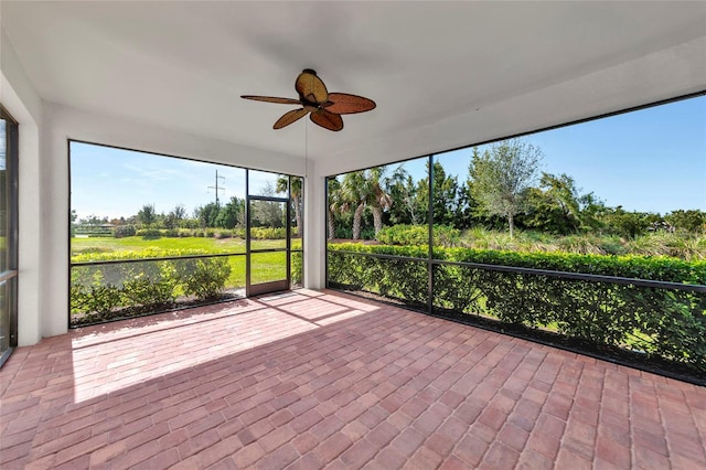 unfurnished sunroom with a ceiling fan