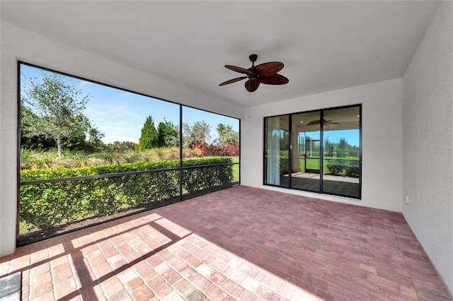 unfurnished sunroom featuring plenty of natural light and a ceiling fan