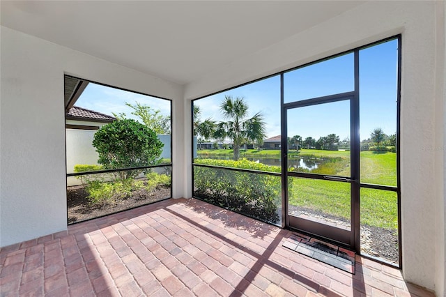 unfurnished sunroom featuring a water view