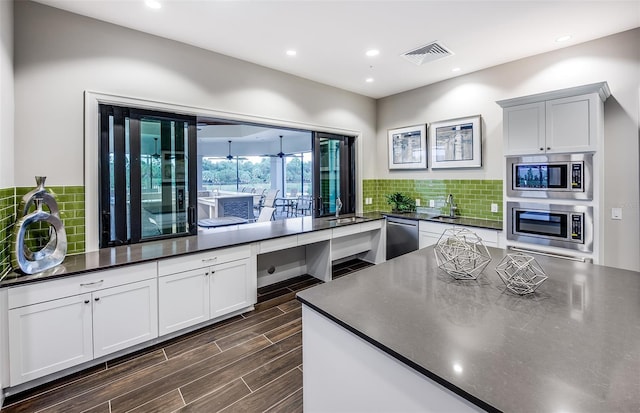 kitchen with decorative backsplash, stainless steel appliances, and white cabinets