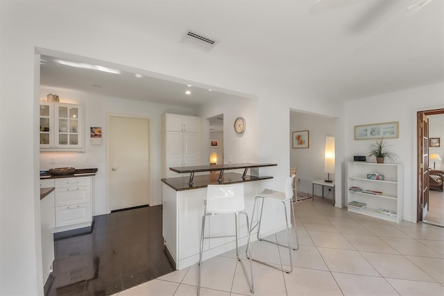 kitchen with white cabinetry, a breakfast bar area, and light tile patterned floors