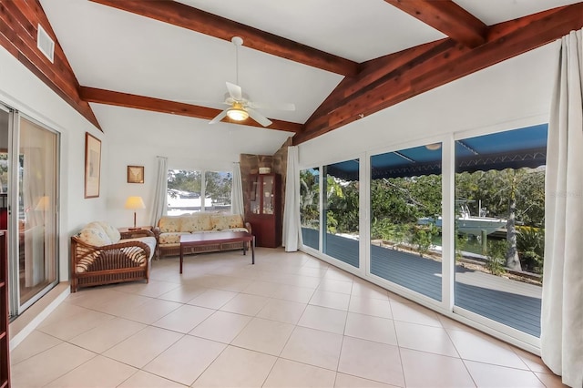 interior space featuring ceiling fan, lofted ceiling with beams, and light tile patterned floors