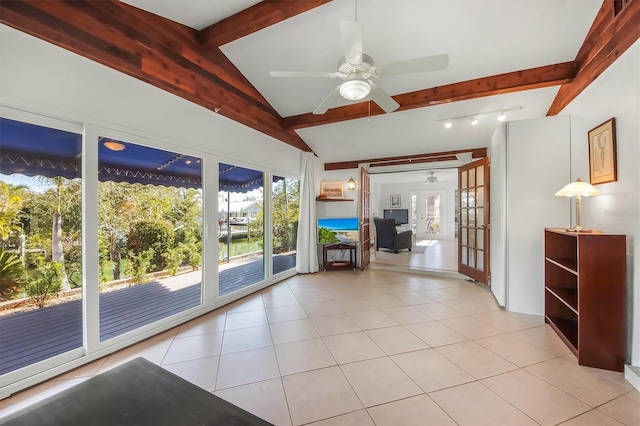 unfurnished living room featuring lofted ceiling with beams, light tile patterned floors, ceiling fan, and french doors