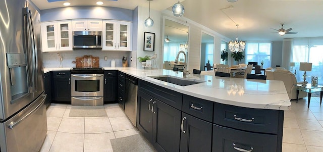 kitchen with sink, stainless steel appliances, kitchen peninsula, and white cabinets