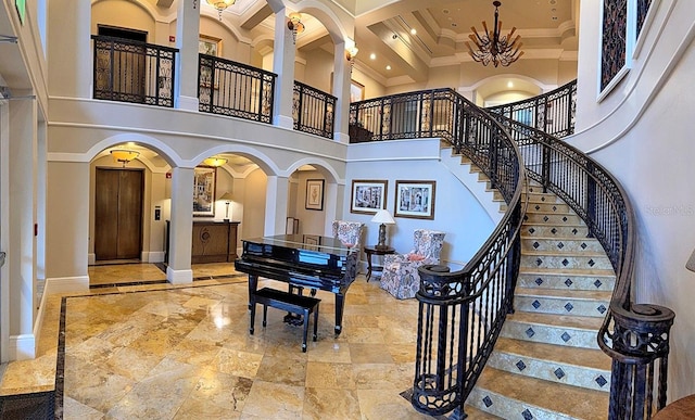 entryway with crown molding and a towering ceiling