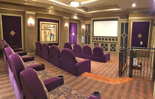 home theater room with a tray ceiling and carpet floors