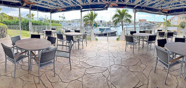 view of patio featuring a gazebo, ceiling fan, and a water view