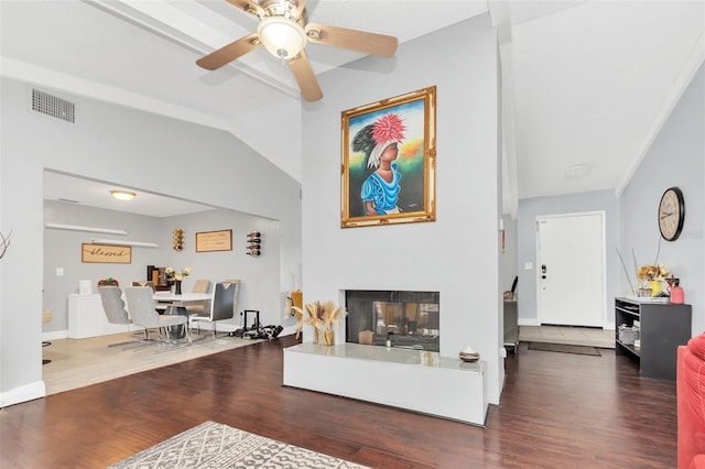 living room featuring hardwood / wood-style flooring, a multi sided fireplace, ceiling fan, and vaulted ceiling